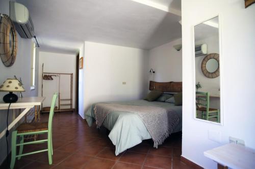 - une chambre avec un lit, un bureau et un miroir dans l'établissement Masseria Procacci, à Ischitella