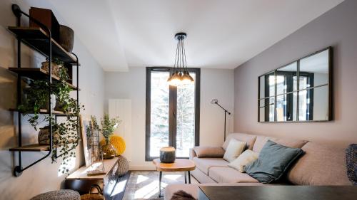 a living room with a couch and a mirror at Chalets Patchwork in Valloire
