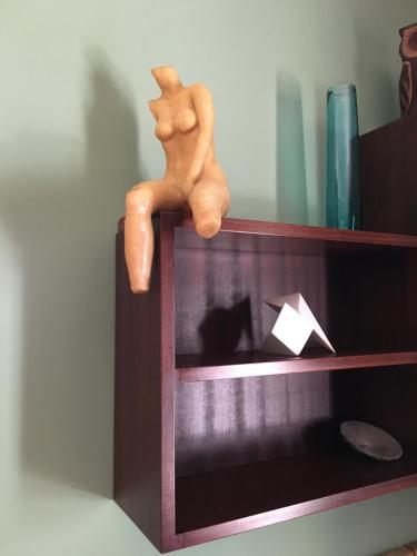 a toy man sitting on top of a shelf with a cat at Vagos Art.Lab in Vagos