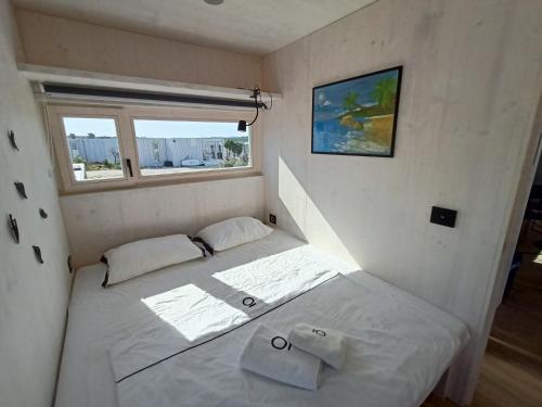 uma pequena cama num pequeno quarto com uma janela em BUQEZ RESORT, Vila 51 em Drage