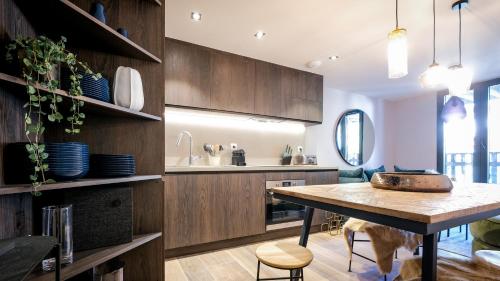 une cuisine avec des armoires en bois et une table en bois dans l'établissement Chalets Patchwork, à Valloire