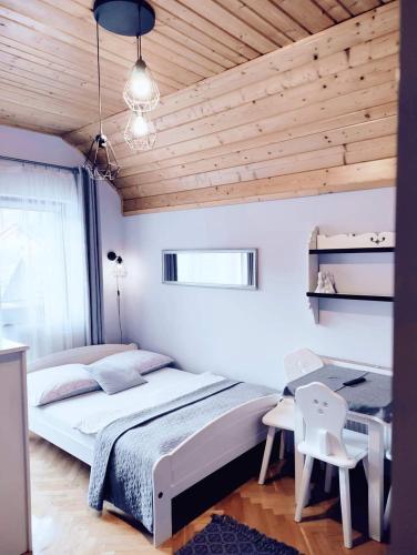 a bedroom with a large bed and a wooden ceiling at Podkowa in Myślenice