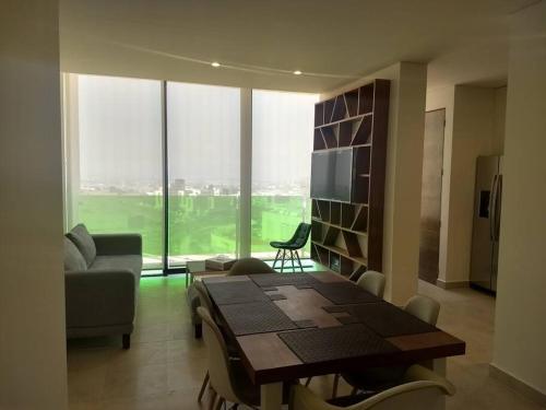 a living room with a table and a couch at Nuevo y Lujoso departmento residencial Querétaro. in Querétaro