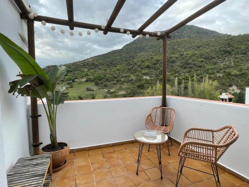 einen Balkon mit 2 Stühlen und einem Tisch mit Aussicht in der Unterkunft Suite Rural Oasis in Benamahoma