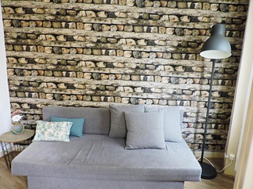 a brick wall behind a couch in a living room at New Charming Flat - Lisbon Center in Lisbon