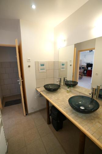 deux lavabos dans une salle de bain avec deux miroirs dans l'établissement Camping Arbre de Vie, à Montagnac