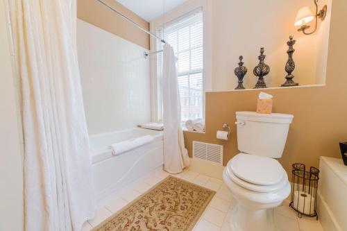 a bathroom with a toilet and a tub and a shower at Bourbon Manor Bed & Breakfast Inn in Bardstown