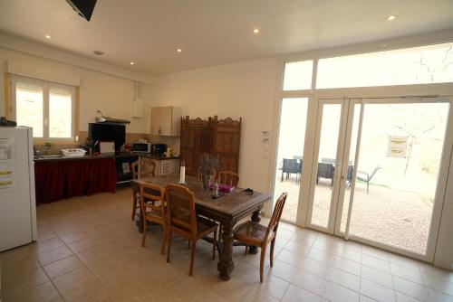 une cuisine avec une table et des chaises en bois et un réfrigérateur dans l'établissement Camping Arbre de Vie, à Montagnac