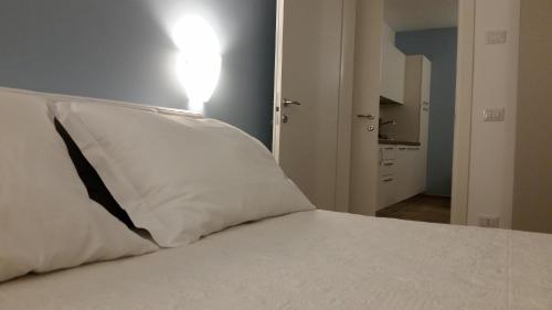 a bed with a white pillow sitting on top of it at Casa Mafalda in Chioggia