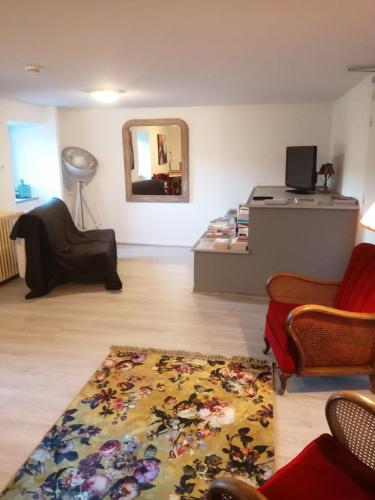 a living room with a table and a mirror at LE RELAIS DE LA FONTAINE in Échandelys