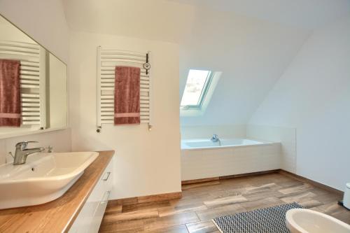 a white bathroom with a sink and a tub at Słoneczna Solina Bóbrka in Solina