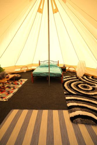 Cette chambre comprend une tente avec un lit. dans l'établissement Camping Arbre de Vie, à Montagnac