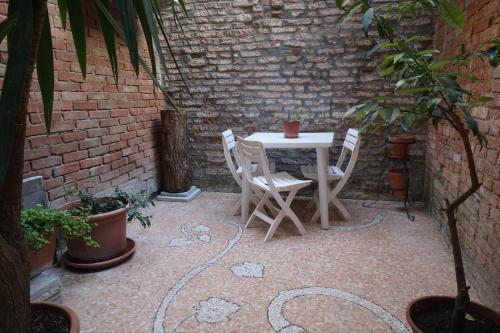 a patio with a table and chairs and a brick wall at Cà Lucy in Venice