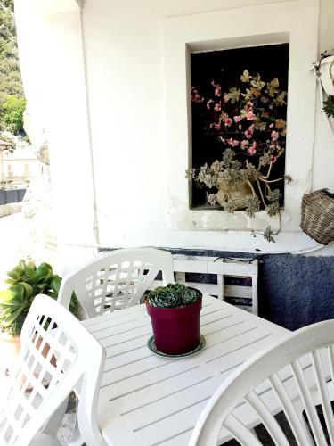 a white table and chairs on a porch with a flower painting at Le Terrazze Sul Pollino B&B in Civita