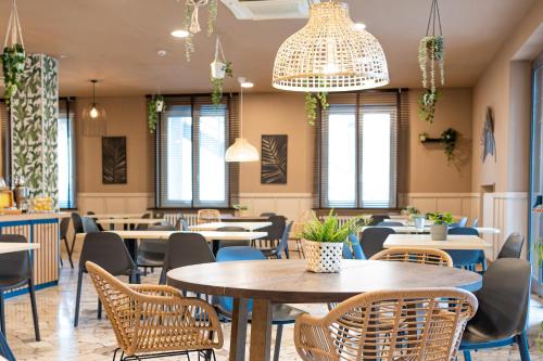 a dining room with tables and chairs and chandeliers at My Place Hotel in Rimini