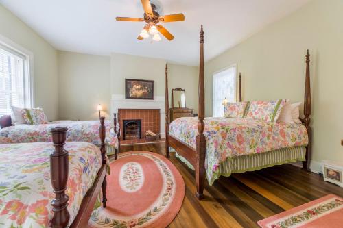 a bedroom with two beds and a fireplace at Bourbon Manor Bed & Breakfast Inn in Bardstown
