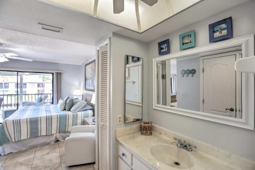 a bathroom with a sink and a bedroom with a bed at Pool and Canal Access Central Cape Coral Condo! in Cape Coral