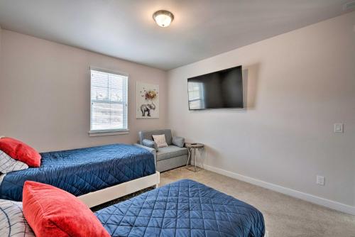a bedroom with two beds and a flat screen tv at Inviting Hideout Townhome with Balcony and Lake Views! in Keetley