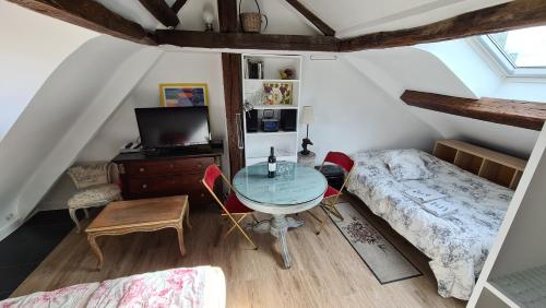 une chambre avec un lit et une table dans une pièce dans l'établissement Appartement Cœur de Paris avec vue sur les toits, à Paris