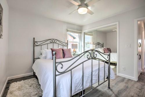 een slaapkamer met een bed met witte lakens en roze kussens bij Charming San Diego Apartment - Walk to Bay! in San Diego