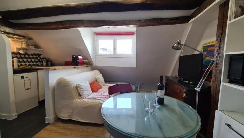 un salon avec une table en verre et un canapé dans l'établissement Appartement Cœur de Paris avec vue sur les toits, à Paris