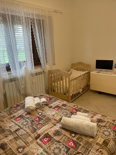 a baby room with two cribs and a bed with a bedspread at La casa di Colino e Annina in Monopoli