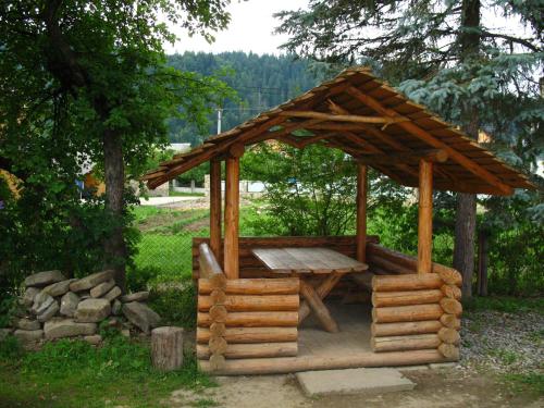 a wooden gazebo with a wooden table on top at АртГір гостинний двір in Mykulychyn