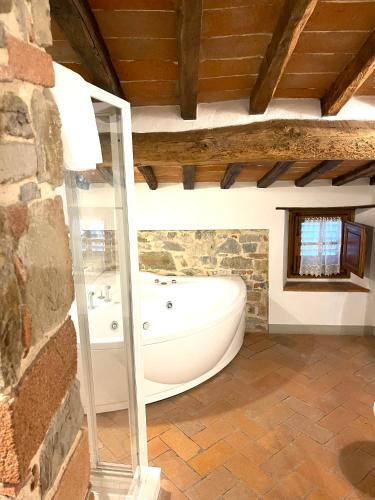 a bathroom with a bath tub in a stone wall at Casale Le Masse in Greve in Chianti
