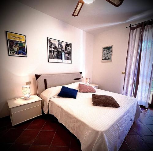 - une chambre avec un grand lit blanc et une table de nuit dans l'établissement Welcome Traveller L'APPARTAMENTO DI ANNALISA, à Garde