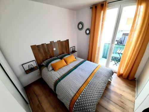 um quarto com uma cama com almofadas laranja em Appartement neuf de 30 m2 au coeur de palavas Classé 2 étoiles em Palavas-les-Flots