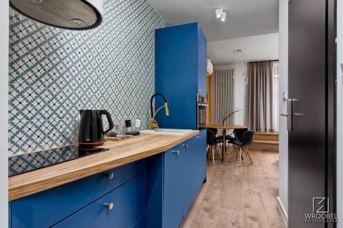 a kitchen with blue cabinets and a blue wall at Zakopiańska Gawra in Zakopane