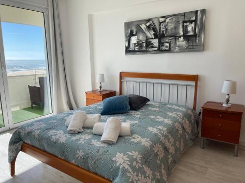 a bedroom with a bed with a view of the ocean at MIRASOL 10 in Figueira da Foz
