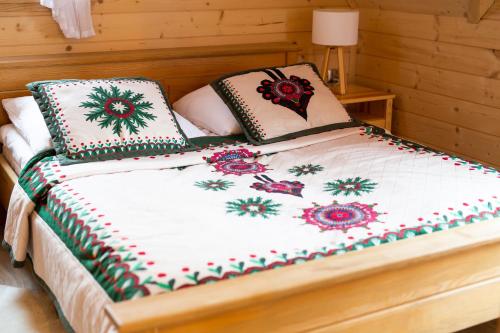 a bed with two pillows on top of it at Eco Domki Podhalanka in Witów