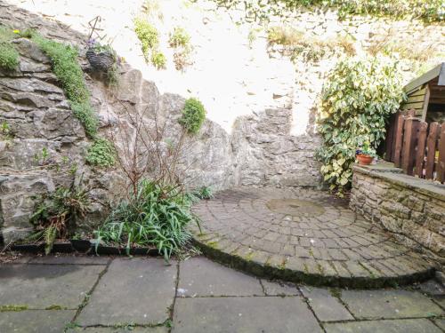 a stone wall next to a brick walkway at 4 Alma Road in Buxton