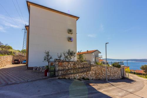 a white building with a stone wall at Marie in Crikvenica
