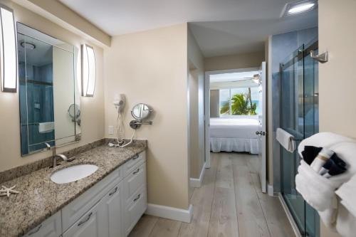 a bathroom with a sink and a shower at Cedar Cove Resort & Cottages in Holmes Beach