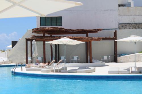 basen z leżakami, parasolami i wodą w obiekcie Cyan Cancun Resort & Spa w mieście Cancún