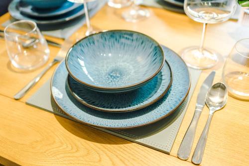 a blue bowl on a plate on a table at Sunshine Cottage by Happy Sunshine Stay in Golborne
