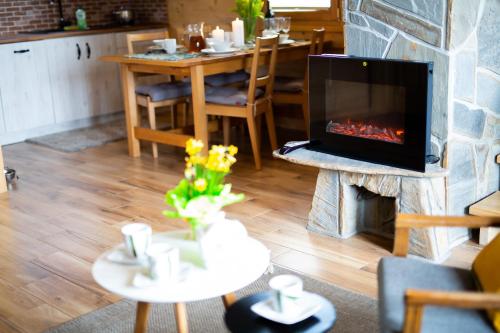 a living room with a fireplace and a table at Eco Domki Podhalanka in Witów