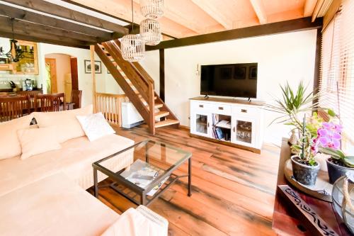 ein Wohnzimmer mit Sofa und Fernseher in der Unterkunft Geographer´s Cottage in Siegsdorf