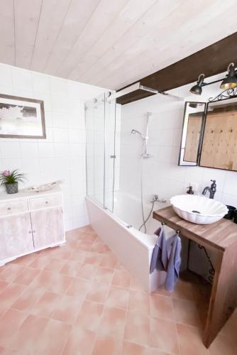 a bathroom with a bath tub and a sink at Geographer´s Cottage in Siegsdorf