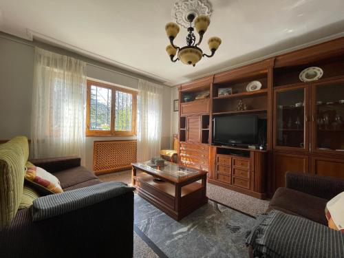 a living room with a couch and a tv at Villa en la Reserva de la Biosfera de Gordón in Huergas y El Millar