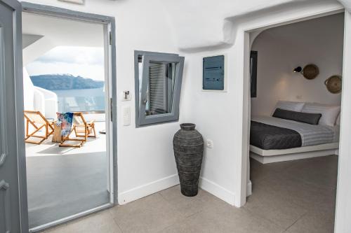 a bedroom with a bed and a balcony at Virginia's Cave Villas in Oia