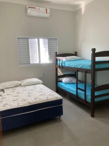 a bedroom with two bunk beds and a window at Recanto Asa Delta in Olímpia