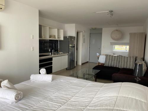 1 dormitorio con 1 cama blanca y sala de estar en Dos Orillas, Apto 208, en Colonia del Sacramento