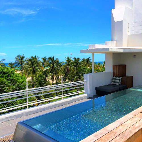 a villa with a swimming pool and a view of the ocean at Hotel Breakwater South Beach in Miami Beach