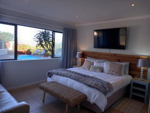 a bedroom with a large bed and a large window at Sola Fide Self Catering Apartment in Jeffreys Bay