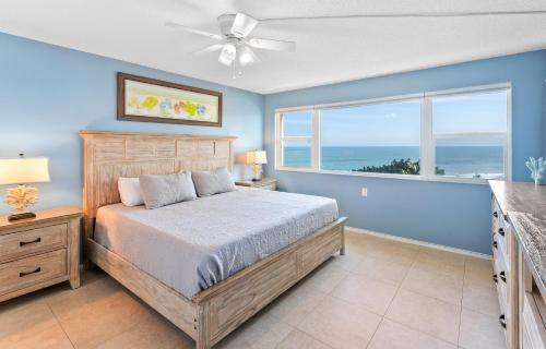 a bedroom with a bed and a window with the ocean at Paradise Beach Club - Ground Floor & Townhouses in Satellite Beach