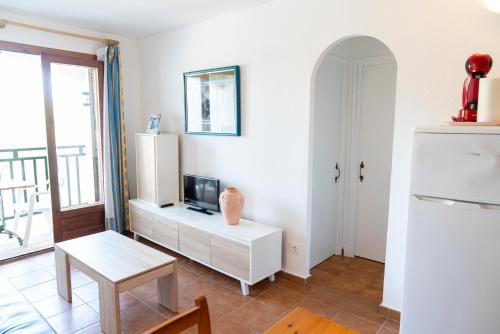 een woonkamer met een witte koelkast en een tafel bij Menorca Arenal d'en Castell in Arenal d'en Castell