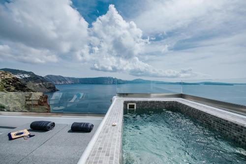 a swimming pool with a view of the water at Virginia's Cave Villas in Oia